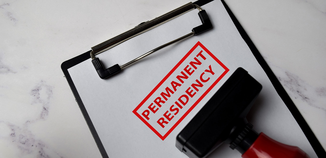 A clipboard with a stamp that reads "permanent residency"